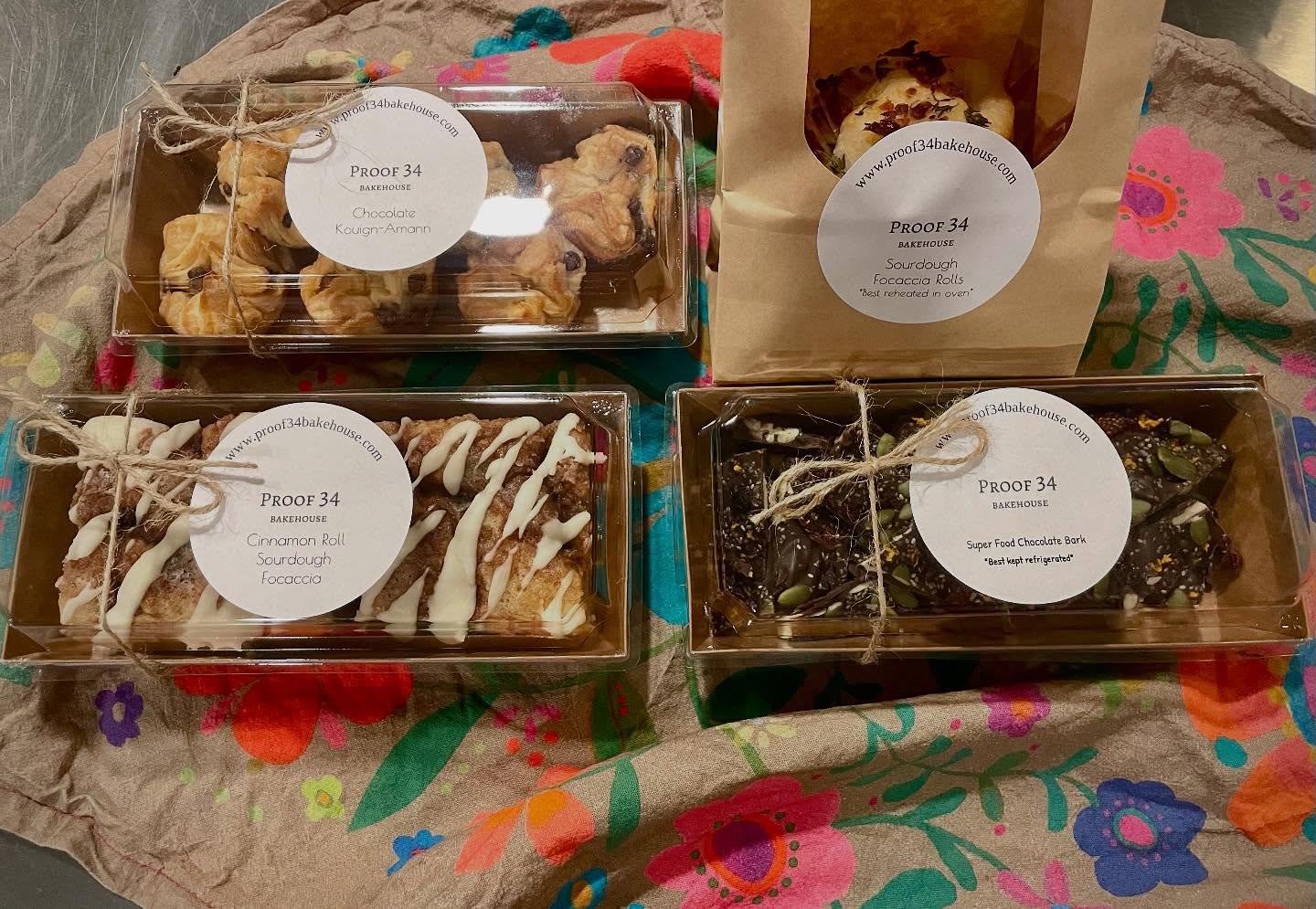 Proof 34 gift boxes packed with pastries, chocolate bark and focaccia rolls